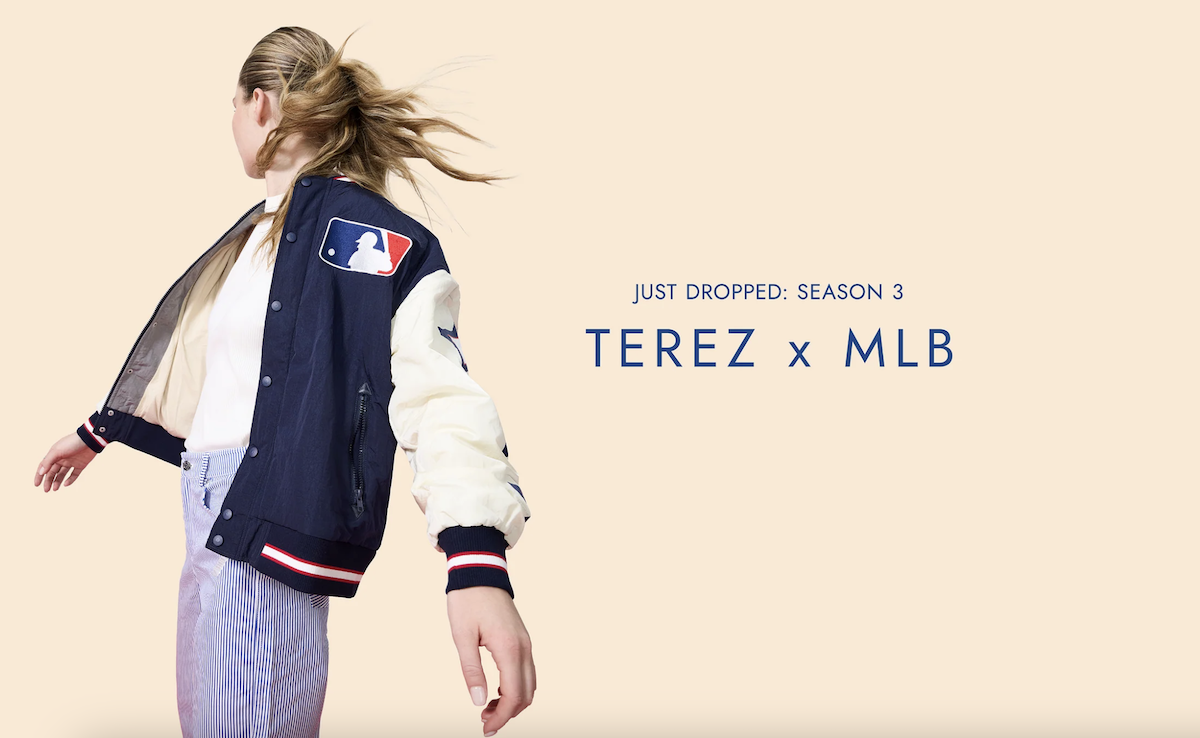 A woman in an MLB jacket from Terez looking away. The background of the image is peachy with blue text that reads 'Just dropped: season 3 Terez x MLB'